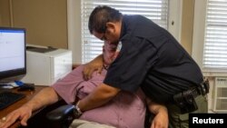 El agente David Valdez abraza al juez de paz de Uvalde, Eulalio Díaz, mientras Díaz cuenta que tuvo que identificar los cuerpos en Uvalde, Texas, el 25 de mayo de 2022. 