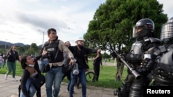 Los periodistas reaccionan cuando la policía los enfrenta durante los enfrentamientos con los manifestantes mientras se realizan protestas contra el gobierno en Bogotá, Colombia, el 29 de junio de 2021.
