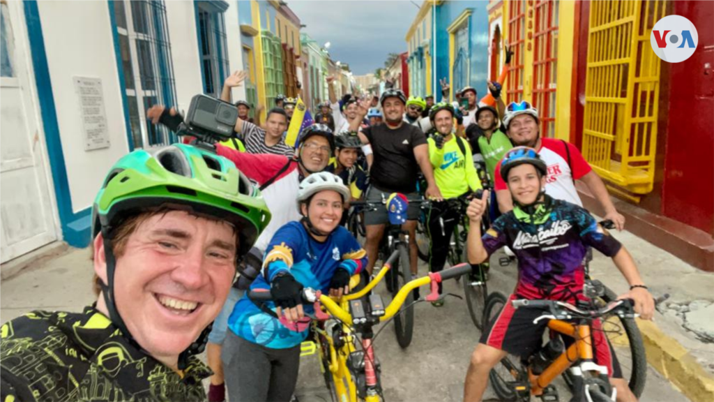 Los esposos mexicanos Juan Pablo y Xiomara Garza, que recorrieron 10 países americanos en 90 días, posan frente al Teatro Baralt de Maracaibo, Venezuela, junto a ciclistas locales.