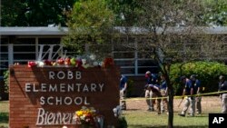 Investigadores buscan pruebas en el exterior de la escuela primaria de Robb en Uvalde, Texas, el 25 de mayo de 2022.