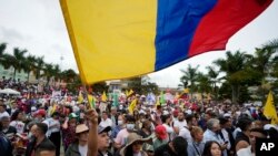 Un partidario del candidato presidencial Gustavo Petro, de la coalición Pacto Histórico, sostiene una bandera nacional colombiana durante un acto de campaña en Fusagasugá, Colombia, el miércoles 11 de mayo de 2022. 