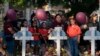 Residente del lugar de la masacre en Uvalde, Texas, se reúne en un sitio conmemorativo para presentar sus respetos a las víctimas que murieron en el tiroteo de esta semana en una escuela primaria, el 26 de mayo de 2022. 