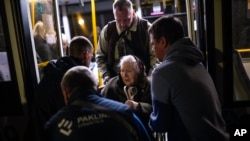 Una mujer que huyó de la planta siderúrgica Azovstal en Mariupol recibe ayuda de un autobús a su llegada a un centro de recepción para personas desplazadas en Zaporizhzhia, Ucrania, el 8 de mayo de 2022.