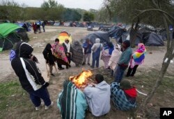 Archivo - Migrantes soportan un tiempo frío alrededor de una fogata en un campamento improvisado en la frontera entre Estados Unidos y México, el 23 de diciembre de 2022 en Matamoros, México.