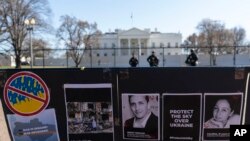ARCHIVO - Carteles e imágenes de reporteros muertos, incluido el periodista Brent Renaud, se muestran en una valla durante una protesta contra la invasión rusa de Ucrania en el Parque Lafayette cerca de la Casa Blanca, el 13 de marzo de 2022 en Washington.