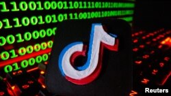 ARCHIVO - Un logotipo de Tik Tok impreso en 3D se muestra en un teclado frente al código binario en esta ilustración tomada el 24 de septiembre de 2021.