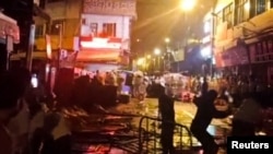 Los manifestantes que protestan por las restricciones de la enfermedad por coronavirus (COVID-19) arrojan botellas de vidrio a la policía antidisturbios en Guangzhou, provincia de Guangdong, China en esta captura de pantalla tomada de un video de las redes sociales publicado el 30 de noviembre de 2022