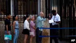 ARCHIVO - Personas hacen fila frente a la embajada de Estados Unidos el día de su reapertura para los servicios consulares y de visas en La Habana, Cuba, el 4 de enero de 2023.