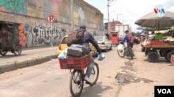 Después de realizar sus compras, Daniel Córdoba, ajusta cuidadosamente sus víveres en un canasto improvisado en su bicicleta. [Foto: Federico Buelvas]