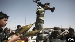 Soldados que desertaron de las fuerzas de Gadhafi y opositores celebran el haber recuperado el control de la ciudad portuaria y petrolera de Brega, en Libia.