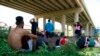 ARCHIVO - Migrantes esperando a ser procesados por la Patrulla Fronteriza tras cruzar de forma ilegal el Río Bravo desde México y hasta Estados Unidos, en Eagle Pass, Texas, en agosto de 2022. 