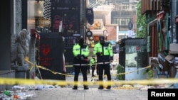 Policías protegen sitio de una estampida en Seúl, Corea del Sur, durante las festividades de Halloween en que murieron 158 personas, el 30 de octubre de 2022.