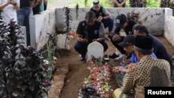 Los jugadores y funcionarios del Arema FC rezan ante las tumbas de las víctimas que murieron durante un motín y una estampida después de un partido de fútbol entre Arema y Persebaya en el estadio Kanjuruhan en Malang, provincia de Java Oriental, Indonesia, el 3 de octubre de 2022, en esta foto tomada por Antara Foto. Antara Foto/H Prabowo/vía REUTERS