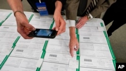 ARCHIVO - Un observador fotografía boletas provisionales del condado de Lehigh mientras continúa el conteo de votos en las elecciones generales, del 6 de noviembre de 2020, en Allentown, Pensilvania, EEUU.