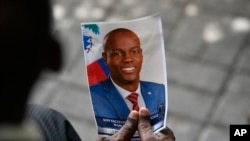 Una persona sostiene una foto del difunto presidente haitiano Jovenel Moise durante su ceremonia conmemorativa en el Museo Nacional del Panteón en Puerto Príncipe, Haití, el 20 de julio de 2021.