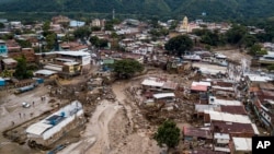 Calles inundadas luego de fuertes lluvias que provocaron el desbordamiento de un río en Las Tejerías, Venezuela, el domingo 9 de octubre de 2022. (Foto AP/Matias Delacroix)