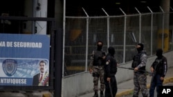 ARCHIVO - Un grupo de agentes de la policía política venezolana, SEBIN, con el rostro cubierto, hacen guardia en la puerta principal de la sede del SEBIN en Caracas, Venezuela, el miércoles 16 de mayo de 2018.