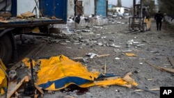 El cuerpo de un hombre está cubierto por una lona de un camión dañado luego de un bombardeo ruso de una fábrica en Kramatorsk, en el este de Ucrania, el 19 de abril de 2022.