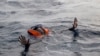 FILE - A migrant tries to board a boat of the German NGO Sea-Watch in the Mediterranean Sea, Nov. 6, 2017.