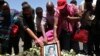 United Nations workers hold a framed photograph as they mourn their colleagues during a commemoration ceremony for the victims at the scene of the Ethiopian Airlines Flight ET 302 plane crash, near the town of Bishoftu, near Addis Ababa, Ethiopia, March 15, 2019. 