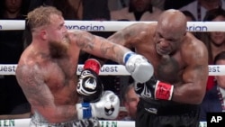 Jake Paul, kiri, melawan Mike Tyson dalam pertandingan tinju kelas berat, Jumat, 15 November 2024, di Arlington, Texas. (Foto: AP)