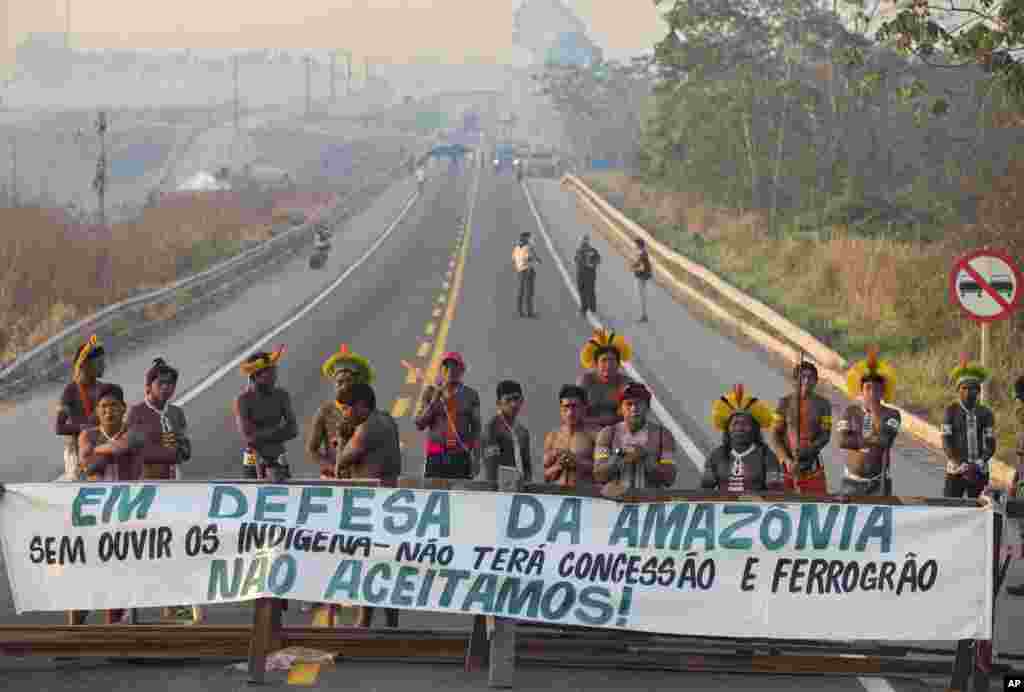 Kayapo Indigenous protesters block highway BR-163 with a banner that reads in Portuguese &quot;Defending the Amazon. Without listening to Indigenous people, there will be no concession and nor grain railway,&quot; near Novo Progresso, Para state, Brazil.