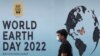 Un hombre pasa junto a un cartel, durante una campaña de limpieza de playas el día de la Tierra, en Mumbai, India, el 22 de abril de 2022.