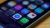 FILE - A WhatsApp icon (bottom, center) is seen on an iPhone in this March 27, 2017, illustration photo. WhatsApp is among the services subject to Uganda's new social media tax.