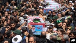 Imagen difundida por la Presidencia Iraní muestra los ataúdes, envueltos en banderas, del presidente Ebrahim Raisi y quienes lo acompañaban en el choque del helicóptero en que viajaban el domingo, durante su funeral en la ciudad de Mashhad, Irán, el 23 de mayo de 2024.