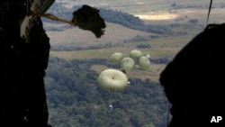 Hrana ,koja će biti isporučena domorodačkom narodu Yanomami, se ispušta iz vojnog transportnog aviona u vojnu bazu Surucucu, u državi Roraima, Brazil, 26. januara 2023. Teška pothranjenost i bolesti, posebno malarija, desetkuju populaciju Yanomami.