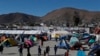 FILE - Migrants walk inside a former concert venue serving as a shelter in Tijuana, Mexico, Dec. 3, 2018.