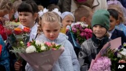 Escolares, la mayoría de ellos de primer grado, participan en una ceremonia que marca el inicio de clases en una escuela en Nakhabino, al oeste de Moscú, el 1 de septiembre.