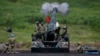 FILE - Japanese Ground Self-Defense Force soldiers fire a self-propelled howitzer during annual exercises near Mount Fuji at Higashifuji training field in Gotemba, west of Tokyo, Aug. 19, 2014.