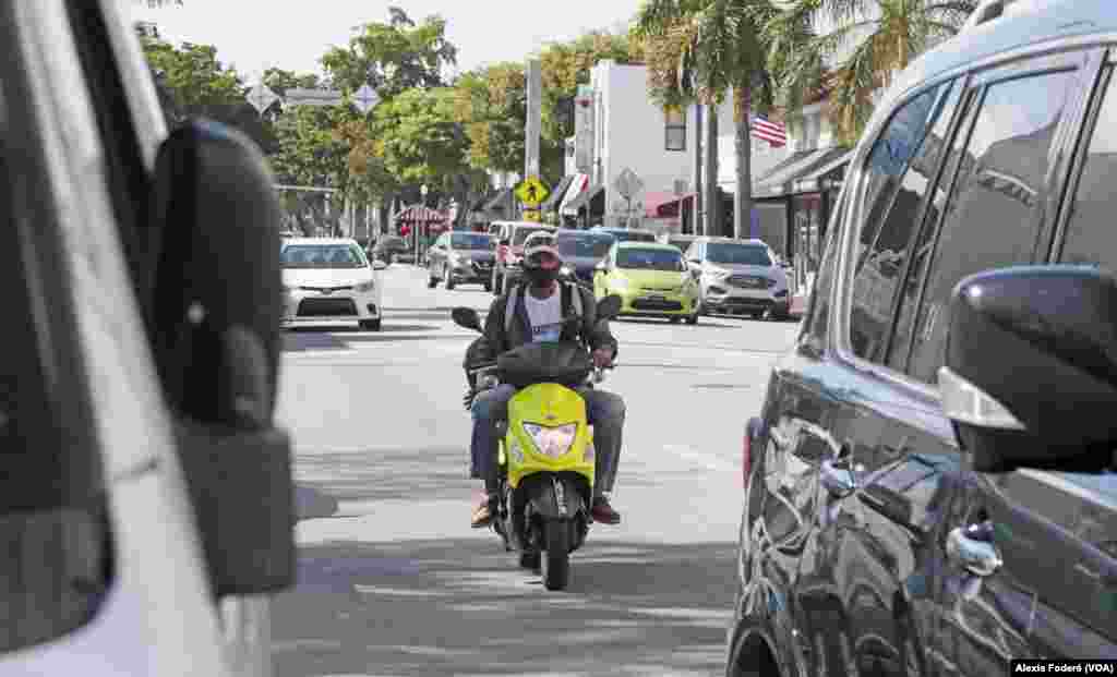 Un scooter es conducido por la Calle 8, en la Pequeña Habana, en Miami, el 25 de enero de 2023. Debido a que por sus características las &quot;motorinas&quot; pueden ser registradas sin necesidad de una licencia de conducción, muchos migrantes las utilizan como medios asequibles de transporte para hacer trámites y buscar trabajo.&nbsp;