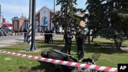 Militares ucranianos junto a un fragmento de un misil Tochka-U después del bombardeo ruso en la estación de tren de Kramatorsk, Ucrania, el viernes 8 de abril de 2022. (Foto AP/Andriy Andriyenko)