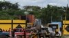 Vehículos que transportan chatarra esperan fuera de un centro de acopio para descargar, en Guanta, Venezuela, el 20 de diciembre de 2021.