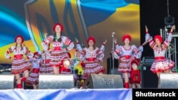 UKRAINE – People in traditional Ukrainian clothing performs on a stage during outdoor free ethno-rock festival Kozak Fest. Dnipropetrovsk region, June 2, 2018