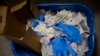 FILE - a view of a waste basket with syringes and gloves after residents received a dose of the third Pfizer COVID-19 vaccine, at San Jeronimo nursing home, in Estella, northern Spain, Sept. 23. 2021. 