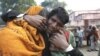 An Indian man whose two relatives died in a stampede at a railway station cries and comforts other relative as they arrive to take the bodies from a morgue, in Allahabad, India, February 11, 2013.