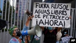 Manifestante sostiene una pancarta que dice en español "Fuera Repsol aguas libres de petróleo Ahora!" durante una protesta frente a la oficina de Repsol en Lima, Perú, el jueves 27 de enero de 2022.