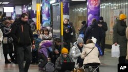 La gente se reúne en una estación de metro que se utiliza como refugio antiaéreo durante un ataque con cohetes en Kiev, Ucrania, el 26 de enero de 2023.