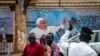 Un oficial de la policía de tránsito parado frente a un mural del Papa Francisco en la pared de una iglesia dirige los vehículos en Juba, Sudán del Sur, el 2 de febrero de 2023.
