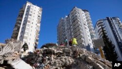 Los equipos de emergencia buscan personas entre los escombros de un edificio destruido en Adana, en el sur de Turquía, el 7 de febrero de 2023.