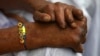 Seorang penderita kusta mengenakan "Rakhi" (benang suci) saat berlangsungnya festival Raksha Bandhan di Kushat Aashram, rumah bagi orang yang terkena kusta, di kota Chandigarh, India utara, 5 Agustus 2009. (REUTERS/Ajay Verma)