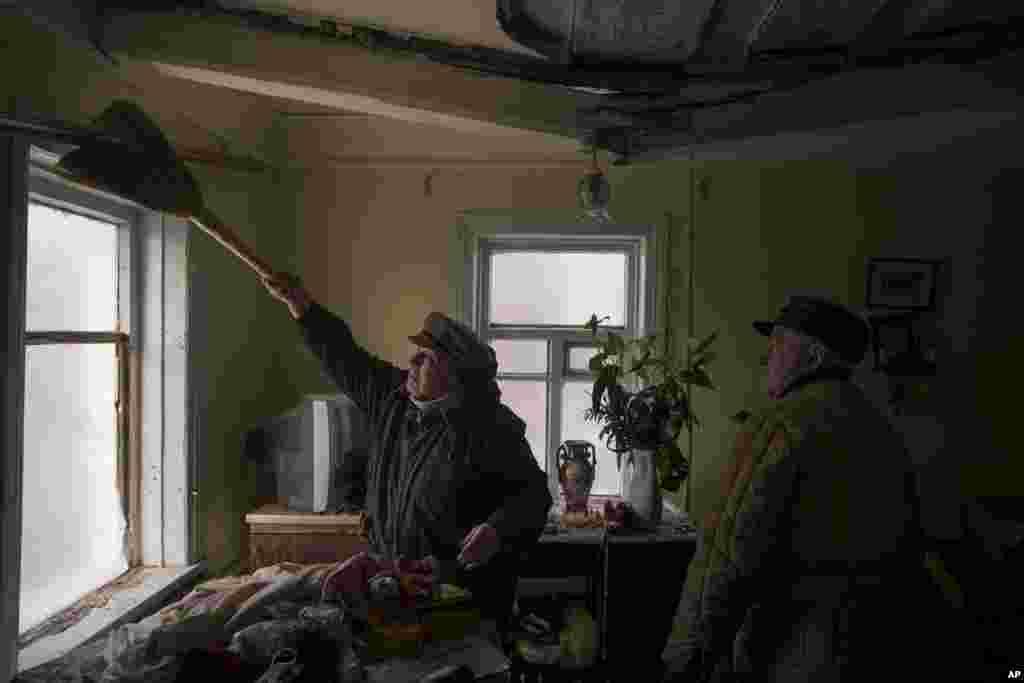 Galina ayuda a limpiar la casa de un vecino que resultó dañada por un bombardeo ruso en Baryshivka, al este de Kiev, Ucrania, el viernes 11 de marzo de 2022. (Foto AP/Felipe Dana)