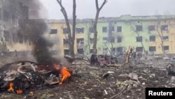 Autos y un edificio de un hospital destruidos por un ataque aéreo en medio de la invasión rusa de Ucrania se ven en Mariupol, Ucrania, en esta imagen de folleto publicada el 9 de marzo de 2022. (Servicio de prensa de la Policía Nacional de Ucrania/Folleto a través de Reuters)