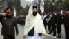 El ministro interino del Interior talibán, Sirajuddin Haqqani, centro, pasa revista a los nuevos reclutas de la policía afgana durante una ceremonia de graduación en la academia de policía en Kabul, Afganistán, el 5 de marzo de 2022.