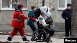Un militar herido es escoltado por trabajadores médicos, luego de un ataque a la base militar de Yavoriv, en medio de la invasión rusa de Ucrania, en un hospital en Novoyavorivsk, Ucrania, el 13 de marzo de 2022.