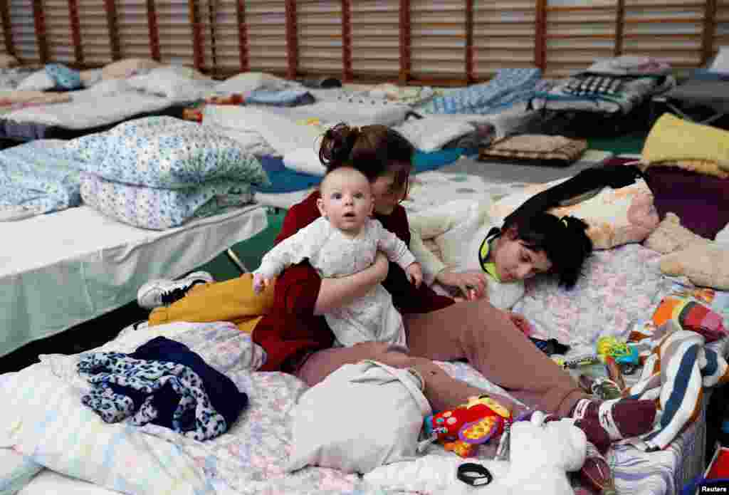 Una madre sostiene a su bebé en un centro para refugiados en Tiszabecs, Hungría.