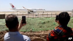 ARCHIVO - Los residentes observan cómo un avión de pasajeros de China se prepara para despegar en un vuelo de prueba desde el nuevo Aeropuerto Internacional Daxing de Beijing el lunes 13 de mayo de 2019.